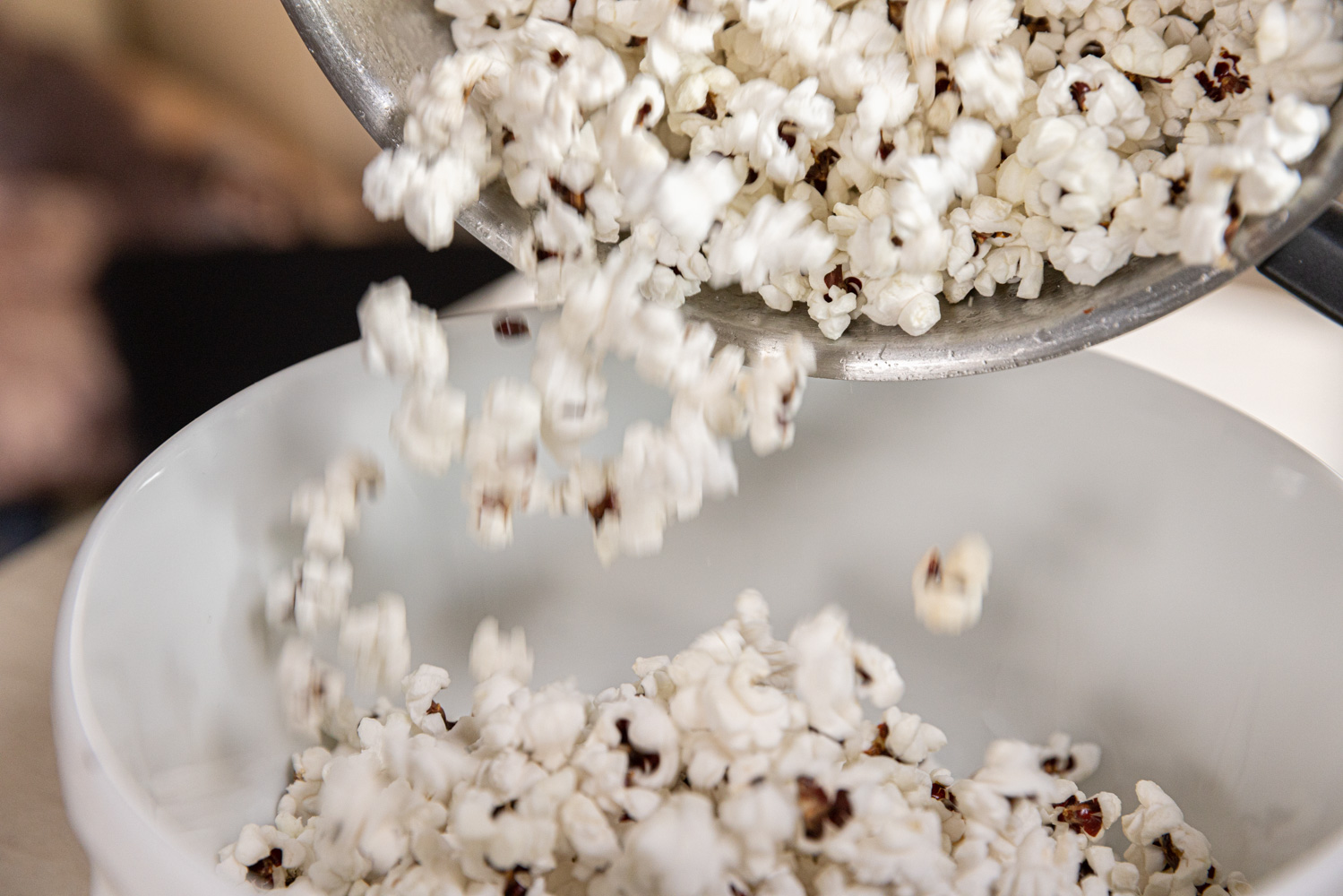 Popcorn hälls ur en kastrull ner i en skål.