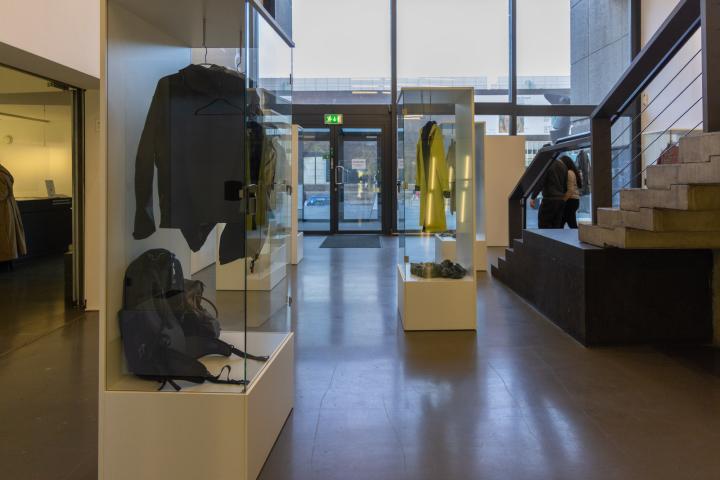Museum med besökarnas kläder i inglasade montrar.