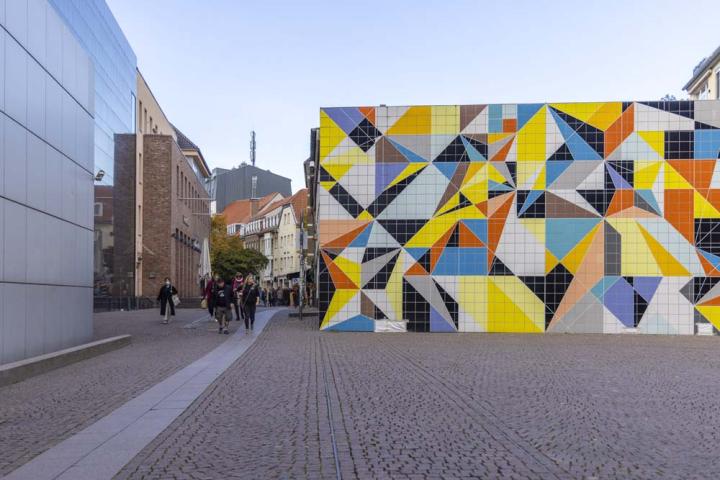 Gata med gatsten och en färgglad byggnad med geometriska mönster.