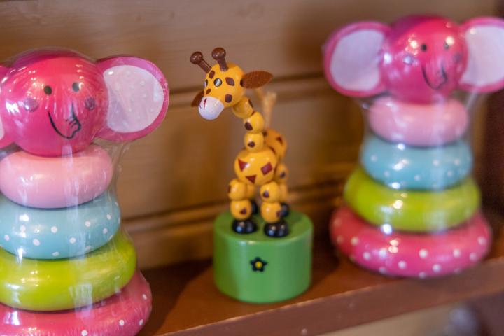 Leksaker på en hylla. Två möss vars kroppar består av målade träringar omgärdar en giraff med ledad kropp.